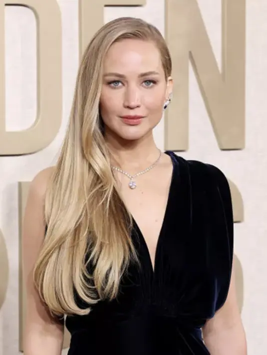 Gaya Old Hollywood Glam menjadi key look yang ditampilkan oleh Jennifer Lawrence. Rambut terurai dengan belahan satu sisi disertai makeup yang bernuansa peach semakin optimalkan kecantikannya.  [Foto: Instagram/ JenniferLawrence]