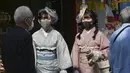 Pengunjung berpakaian kimono yang mengenakan masker untuk melindungi diri dari penyebaran virus corona berjalan-jalan di distrik perbelanjaan Asakusa di Tokyo, Jepang, Rabu (14/10/2020). Tokyo mengonfirmasi lebih dari 170 kasus virus corona baru pada hari Rabu. (AP Photo/Koji Sasahara)