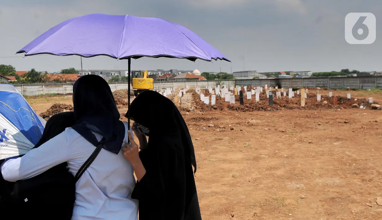 Keluarga jenazah korban COVID-19 menghadiri pemakaman di TPU Rorotan, Cilincing, Jakarta Utara, Kamis (29/4/2021). TPU Rorotan yang menjadi satu-satunya tempat pemakaman jenazah pasien COVID-19 di DKI ini dalam dua minggu terakhir mengalami penurunan intensitas pemakaman. (merdeka.com/Arie Basuki)