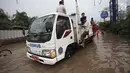 Petugas Dinas Perhubungan (Dishub) mengevakuasi karyawan dan warga yang terjebak banjir di Jalan Boulevard Raya, Kelapa Gading, Jakarta, Kamis (15/2). Banjir diakibatkan guyuran hujan sejak pagi hingga sore. (Liputan6.com/Arya Manggala)