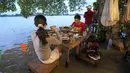 Pelanggan menyantap makanan di tengah banjir yang merendam Chaopraya Antique Café di Sungai Chao Phraya, Bangkok, Thailand, Kamis (7/10/2021). Alih-alih kursi kosong dan meja kosong justru restoran penuh seperti biasanya bagi para pencinta santapan 'hot-pot'. (AP Photo/Sakchai Lalit)