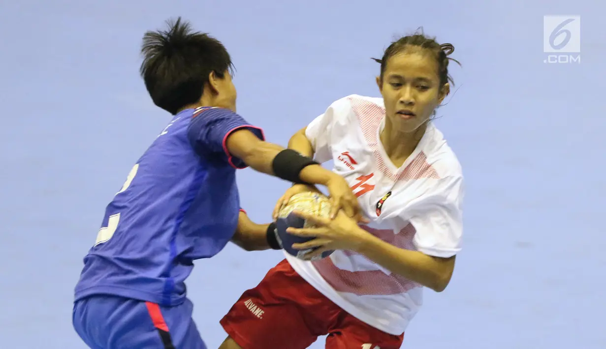 Pemain bola tangan putri Indonesia, Marselina (kanan) berebut bola dengan pemain Thailand pada babak penyisihan grup B Asian Games 2018 di Jakarta, Kamis (16/8). Indonesia kalah 16-34. (Liputan6.com/Helmi Fithriansyah)