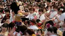 Tokoh Minnie Mouse menyambut para gadis dan pria pada perayaan Coming of Age Day atau Hari Kedewasaan di Tokyo Disneyland, di Urayasu, Senin (13/1/2020). Hari Kedewasaan adalah hari libur umum Jepang yang diadakan setiap hari Senin, minggu kedua di bulan Januari tiap tahunnya. (Kazuhiro NOGI/AFP)