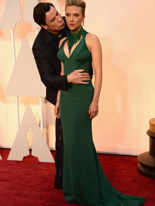 John Travolta mencium Scarlett Johansson. Yup, dalam foto itu ScarJo asli dan bukan patung lilin. ScaJo tetap berdiri tegap dengan memasang aura tak nyaman. Momen ini tentu bikin ngakak orang-orang di sekeliling. (Getty Images/Cosmopolitan)