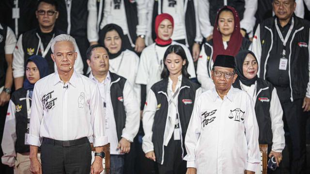 Ganjar Pranowo Tampil Beda di Debat Capres 2024, Kenakan Kemeja Putih Bertuliskan 'Sat Set'. Sementara Mahfud MD Bertuliskan 'Tes Tes' (Liputan6.com/Faizal Fanani)