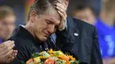 Bastian Schweinsteiger menangis saat mengucapkan salam perpisahan untuk fans dan timnas Jerman usai laga melawan Finlandia di Monchengladbach, Jerman (1/9/2016) dini hari WIB. (AFP/Patrik Stollarz)
