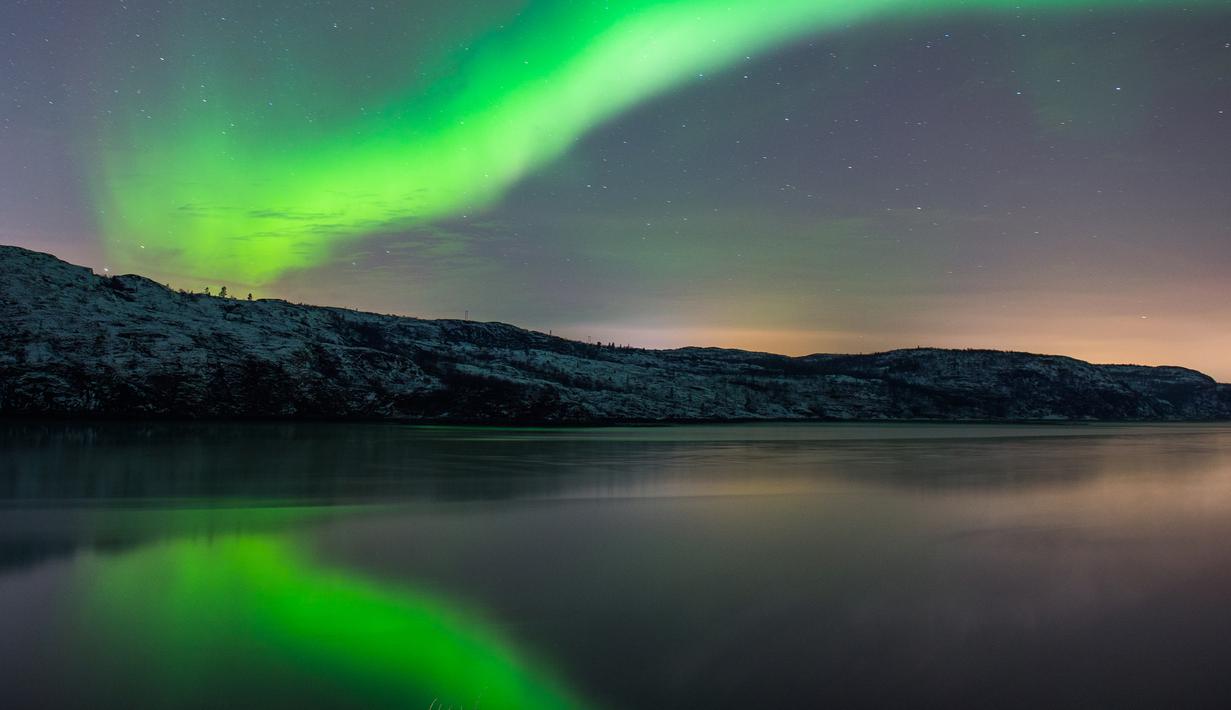 Fenomena aurora borealis saat menerangi langit malam di dekat kota Kirkenes, Norwegia utara, Kamis (12/11/2015). (AFP PHOTO/Jonathan NACKSTRAND)