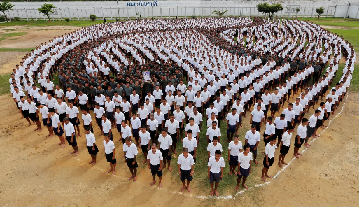 Formasi angka sembilan Thailand yang dibuat para narapidana untuk menghormati mendiang Raja Bhumibol Adulyadej di penjara Pathum Thani, Bangkok, Thailand (27/10). Angka sembilan merupakan perlambang untuk Raja Rama IX. (Reuters/Chaiwat Subprasom)