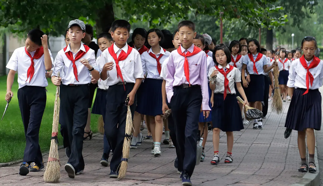 Foto pada 28 Juli 2017 terlihat para pelajar membawa sapu untuk bekerja bakti membersihkan ruang publik dalam upaya menjaga kebersihan kota di Pyongyang, Korea Utara. (AP Photo/Wong Maye-E)