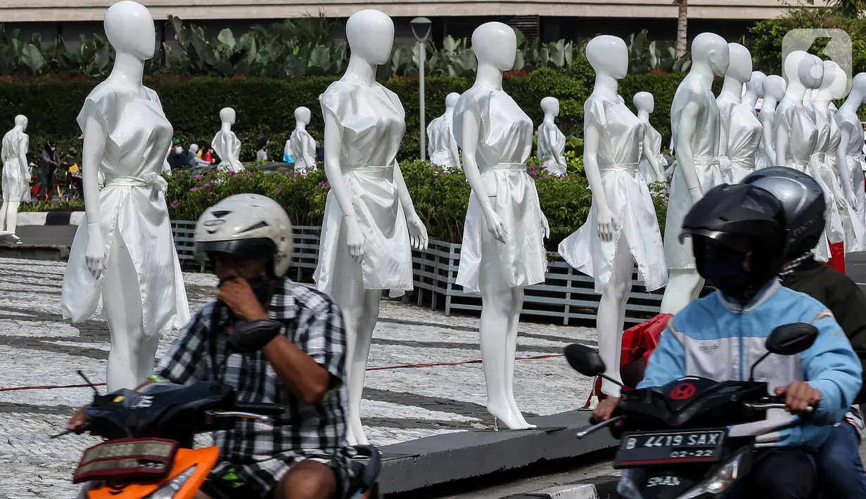 Pengendara melintasi puluhan boneka maneken yang dipajang di Bundaran HI, Jakarta, Minggu (15/11/2020). Boneka maneken tersebut sebagai bentuk "Mengenang Korban Kecelakaan Lalu Lintas 2020" serta kampanye agar masyarakat lebih berhati -hati dan tertib berlalu lintas. (Liputan6.com/Johan Tallo)