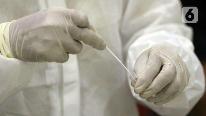 Petugas medis melaksanakan proses rapid test antigen pada salah satu pewarta di ruang wartawan Gedung KPK, Jakarta, Senin (16/11/2020). Rapid Test Antigen dilakukan untuk mendeteksi keberadaan virus SARS-CoV-2 penyebab Covid-19. (Liputan6.com/Helmi Fithriansyah)