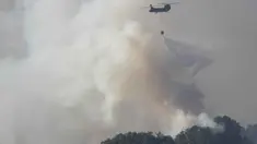 Sebuah helikopter Pasukan Bela Diri Jepang menjatuhkan air ke bagian depan kobaran api di dekat kota Otsuchi, Prefektur Iwate, Jepang pada Sabtu 25 April 2026. Hingga Ribuan petugas pemadam kebakaran masih berjuang memadamkan kebakaran hutan wilayah Otsuchi, Prefektur Iwate, Jepang. (ANDREW CABALLERO-REYNOLDS/AFP)