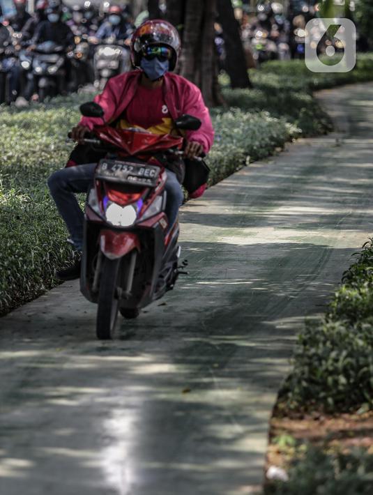 Pengendara motor melintas di atas trotoar pejalan kaki di kawasaan Daan Mogot, Jakarta, Senin (26/4/2021). Padatnya volume kendaraan pada jam kerja di kawasan tersebut membuat sejumlah pengendara motor nekat menggunakan trotoar yang merupakan
hak bagi pejalan kaki. (Liputan6.com/Faizal Fanani)