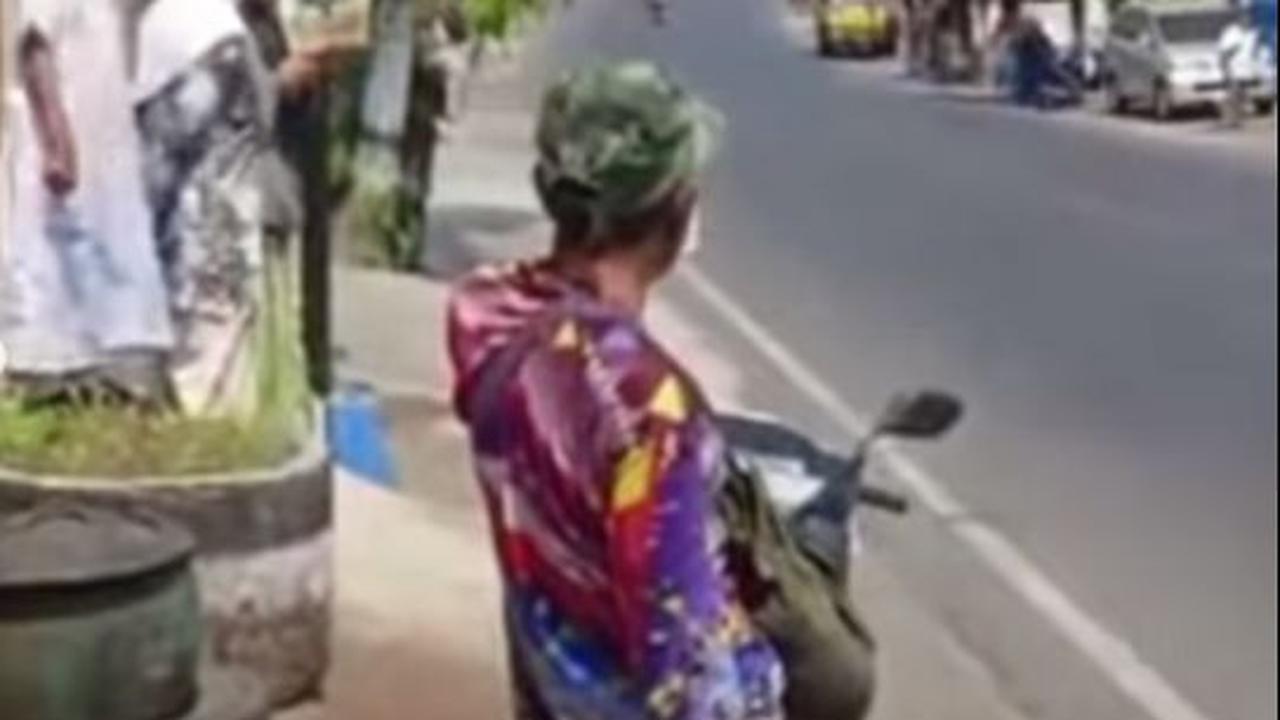 Akun Instagram bernama video_medsos pada mulanya memperlihatkan seorang bapak-bapak yang tengah bersiap merekam iring-iringan Presiden Jokowi. Sekilas tak ada yang aneh dari aksi bapak berbaju warna-warni ini.
