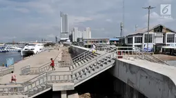 Aktivitas warga lokal di dekat tanggul laut di Pelabuhan Kali Adem, Muara Angke, Jakarta, Selasa (12/2). Pembangunan tanggul laut tersebut merupakan bagian dari program Pengembangan Terpadu Pesisir Ibukota Negara atau NCICD. (Merdeka.com/Iqbal S. Nugroho)