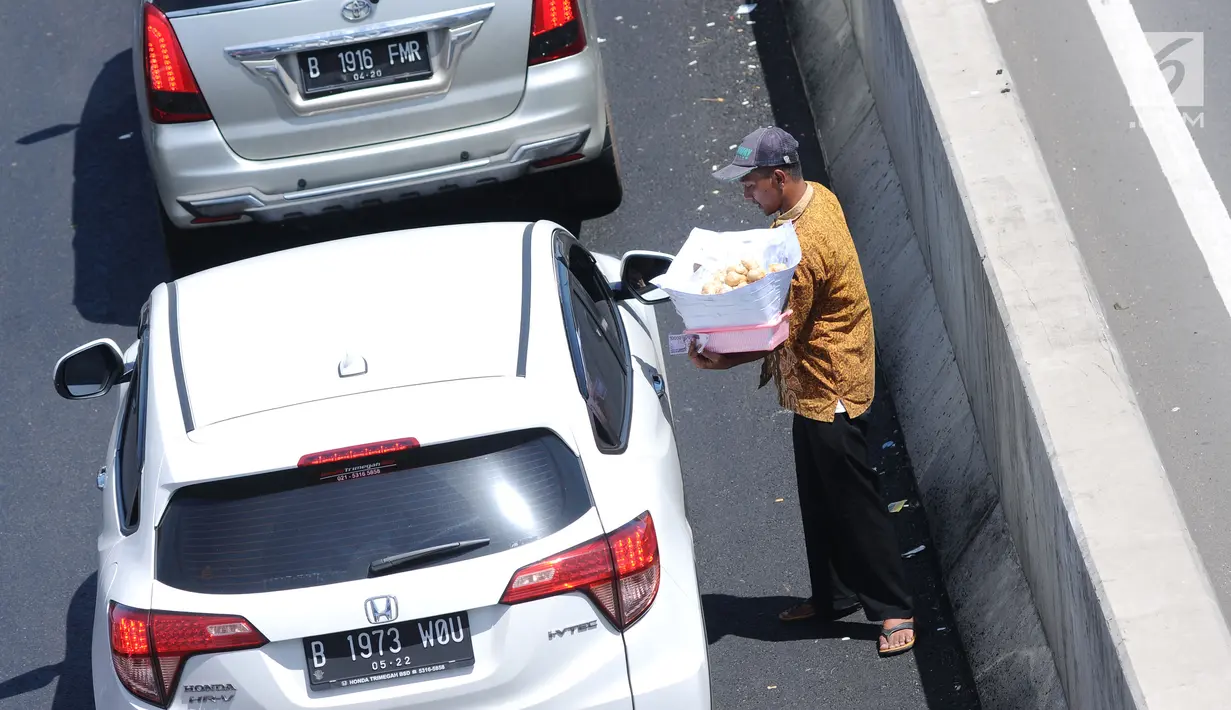 Pedagang menjajakan makanan ringan jelang Simpang Tiga Keluar Tol Brebes, Jawa Tengah, Sabtu (23/12). Memanfaatkan kepadatan arus libur panjang Natal 2017, pedagang menjajakan dagangan di Simpang Tiga Keluar Tol Brebes. (Liputan6.com/Helmi Fithriansyah)