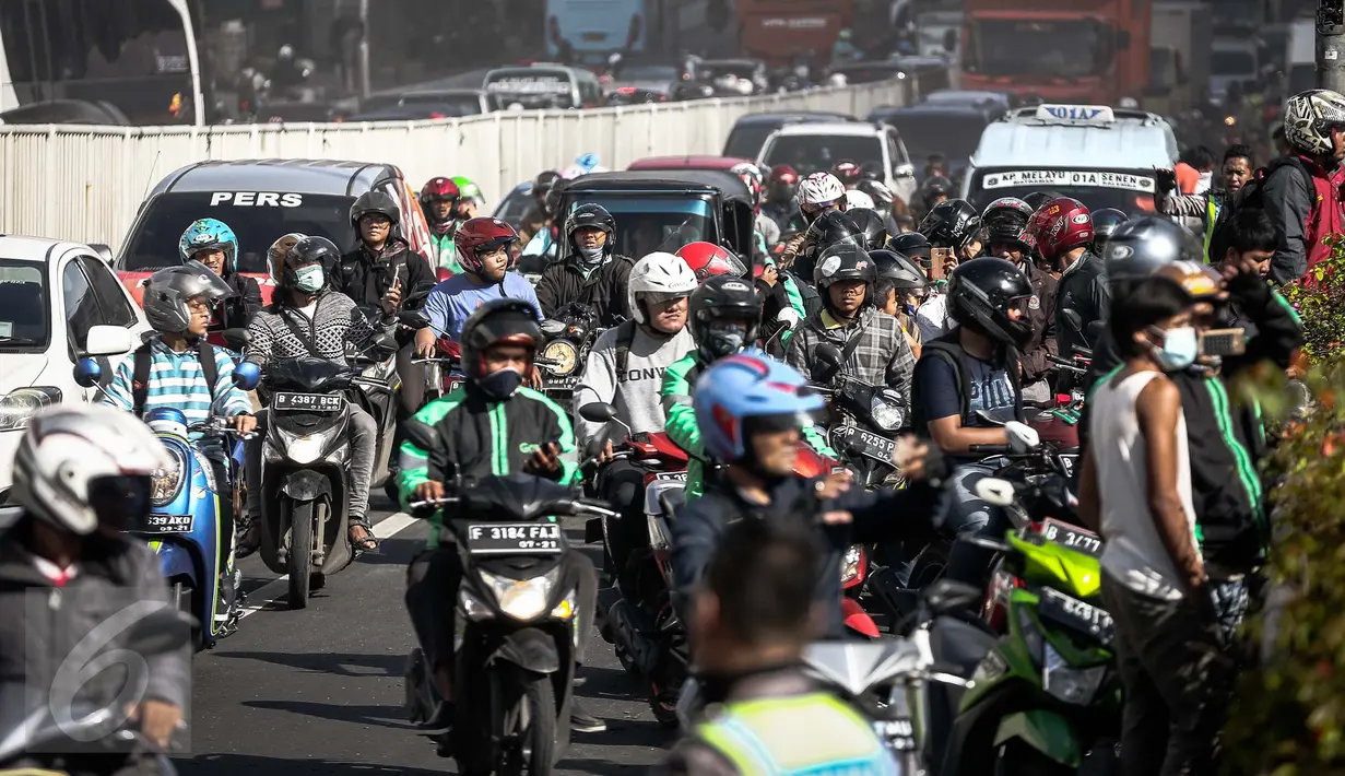 Pengendara motor melambatkan laju kendaraannya untuk melihat kebakaran yang melanda Pasar Senen, Jakarta Pusat, Kamis (19/1). Petugas belum dapat menyimpulkan penyebab kebakaran serta korban dan kerugian yang diakibatkannya. (Liputan6.com/Faizal Fanani)