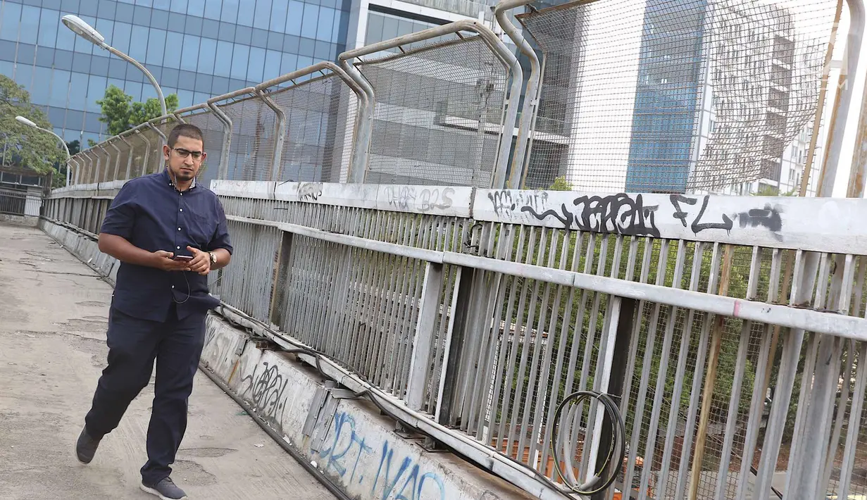 Pejalan kaki melintasi jembatan penyeberangan orang tanpa atap dan tidak terawat di Jalan TB Simatupang, Jakarta, Rabu (10/10). Kondisi tersebut menyebabkan JPO terkesan kumuh serta mengurangi kenyamanan pejalan kaki. (Liputan6.com/Immanuel Antonius)