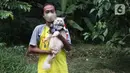 Fredi Lugina Priadi (39) berpose bersama kucingnya yang mengenakan kostum super hero di rumah industri di Desa Jampang, Kabupaten Bogor, Selasa (8/12/2020). Fredi merancang aneka kostum unik untuk kucing dengan harga yang berkisar dari Rp38 ribu hingga Rp1,5 juta. (Liputan6.com/Herman Zakharia)
