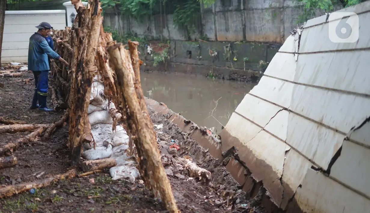 Petugas Sudin SDA Jakarta Selatan memperbaiki tanggul Kali Krukut yang jebol di Jalan Perumahan Kemang Jaya, Bangka, Jakarta, Rabu (8/1/2020). Tanggul jebol akibat tak kuat menahan derasnya air kiriman dari hulu serta hujan deras yang mengguyur kawasan tersebut. (Liputan6.com/Immanuel Antonius)