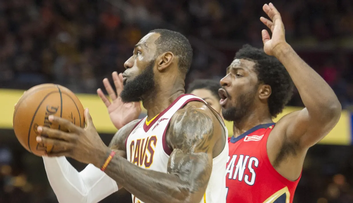 Pebasket Cleveland Cavaliers, LeBron James, berusaha melewati pebasket New Orleans Pelicans,Solomon Hill, pada laga NBA di Quicken Loans Arena, Sabtu (31/3/2018). Cavaliers menang 107-102 atas Pelicans. (AP/Phil Long)