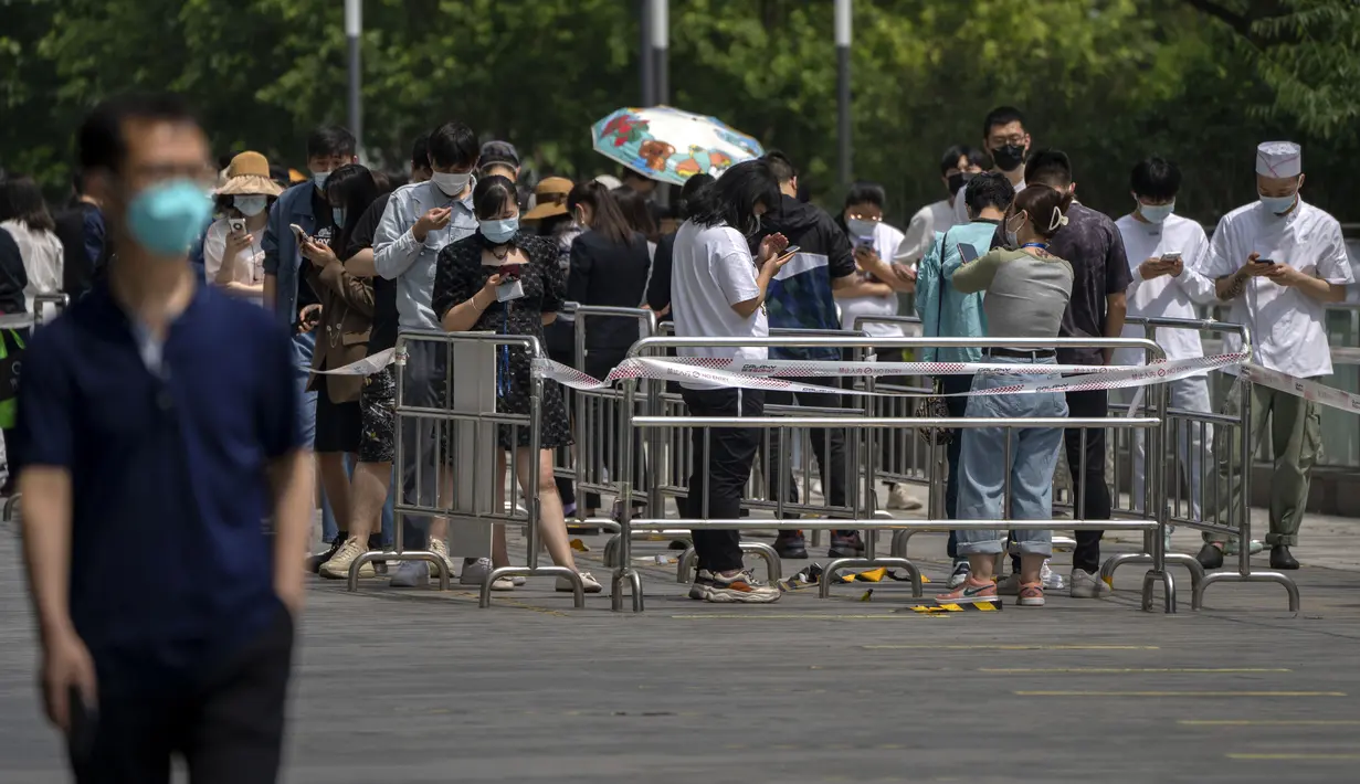 <p>Orang-orang antre tes COVID-19 di tempat pengujian virus corona di Beijing, Kamis (19/5/2022). Sebagian wilayah Beijing menghentikan pengujian massal harian yang telah dilakukan beberapa minggu terakhir, tetapi banyak tempat pengujian tetap sibuk karena syarat tes negatif COVID-19 dalam 48 jam terakhir untuk memasuki beberapa bangunan di ibu kota China. (AP Photo/Mark Schiefelbein)</p>