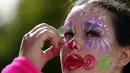 Seorang wanita berdandan seperti badut saat bersiap mengikuti Parade Karnaval Clowns di pantai Sesimbra, Lisbon, Spanyol (12/2). Acara ini diikuti oleh ribuan orang yang mengenakan kostum badut. (AP Photo / Armando Franca)