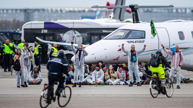 <p>Sekelompok aktivis duduk-duduk di bawah jet pribadi di bandara Belanda. Dok: Greenpeace</p>