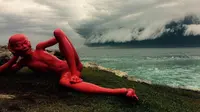 Awan Gelombang 'Tsunami' Muncul di Langit Sydney. Sebuah Patung yang sedang dipamerkan di Pantai Bondi dengan latar belakang awan Tsunami (Reuters)