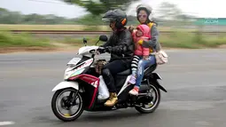 Pemudik sepeda motor dengan membawa anak melintasi kawasan Pantura di wilayah Brebes, Jawa Tengah, Kamis (22/6). Para orang tua membawa anaknya yang masih kecil menggunakan sepeda motor untuk perjalanan mudik lebaran. (Liputan6.com/Johan Tallo)