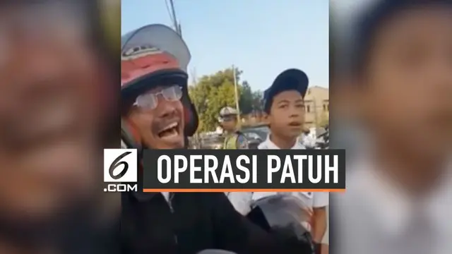 Seorang bapak menangis ketika petugas melakukan razia dalam Operasi Patuh di Makassar, Sulawesi Selatan. Menurut petugas, sang bapak malu karena anaknya tidak mengenakan helm.