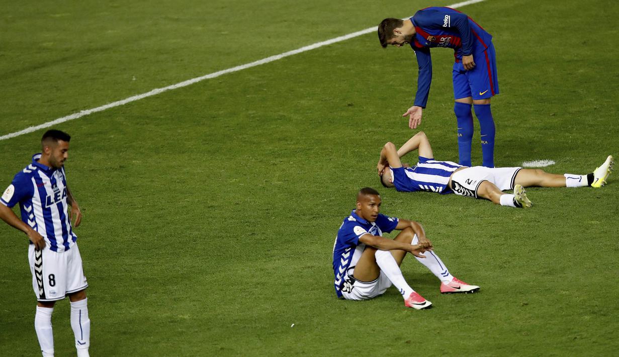 Bek Barcelona, Gerard Pique, menyemangati bek Alaves, Carlos Vigaray, usai kalah pada laga final Copa Del Rey di Stadion Vicente Calderon, Madrid, Sabtu (27/5/2017). Barcelona menang 3-1 atas Alaves. (EPA/Juanjo Martin)