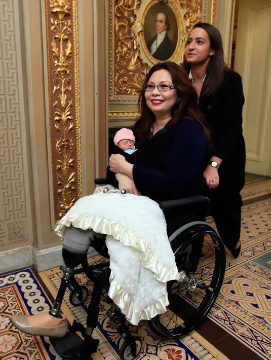 Senator Illinois, Tammy Duckworth membawa bayinya meninggalkan ruang kongres Gedung Capitol Hill, Washington DC, Kamis (19/4). Pekan lalu, Duckworth menjadi senator AS pertama yang melahirkan, saat masih aktif bekerja di Kongres. (AP/Manuel Balce Ceneta)
