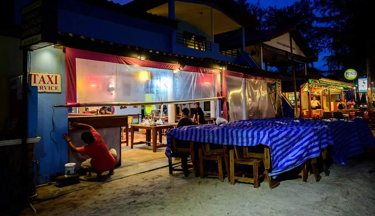 Karyawan mempersiapkan restoran untuk dibuka di pulau Phuket Thailand, ketika negara itu bersiap untuk menyambut pengunjung yang divaksinasi penuh terhadap virus corona Covid-19 tanpa karantina mulai 1 November (25/10/2021). (AFP/Mladen Antonov)