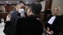 JPU juga mengatakan pertimbangan yang memberatkan tuntutan adalah para terdakwa tidak mendukung program pemerintah dalam pemberantasan tindak pidana korupsi yang bersih dan bebas dari korupsi, kolusi, dan nepotisme. Tampak dalam foto, terdakwa kasus dugaan korupsi tata kelola minyak mentah, Martin Haendra Nata (tengah) usai mengikuti sidang pembacaan tuntutan di Pengadilan Tindak Pidana Korusi (Tipikor), Jakarta, Kamis (23/4/2026). (Kapanlagi.com/Budy Santoso)
