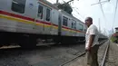 Penjaga perlintasan kereta api tanpa palang pintu, Wandi, menjaga perlintasan di Kawasan Petamburan, Jakarta, Jumat (4/6/2021). Sudah 10 tahun, Bapak Wandi menjaga palang pintu perlintasan kereta api yang kerap dilintasi oleh pengguna jalan untuk menyeberang. (merdeka.com/Imam Buhori)