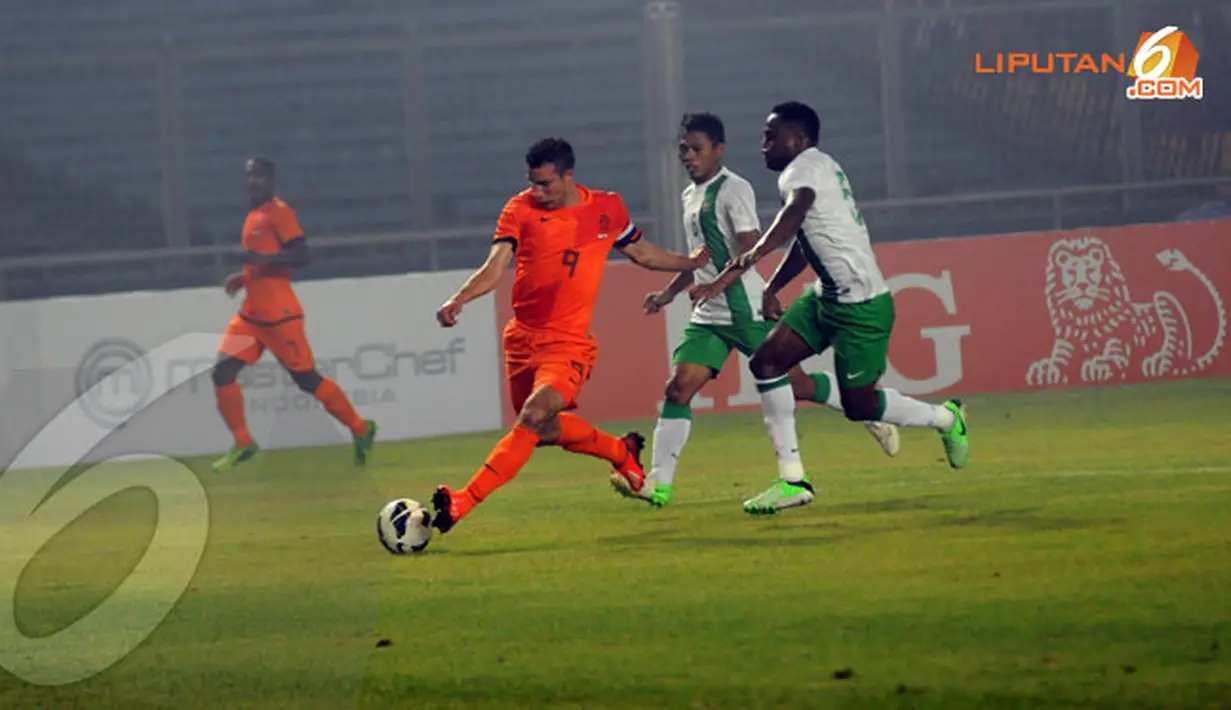 Penyerang Timnas Belanda (Robbin van Persie) mendapat pengawalan ketat dari beberapa pemain belakang Indonesia dalam laga yang digelar di Stadion GBK pada Jumat 7 Juni 2013 (Liputan6.com/Helmi Fithriansyah)