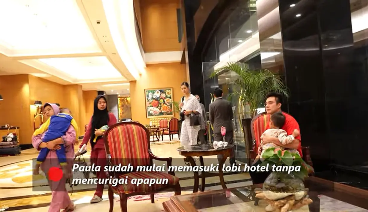 Baim Wong membuat kejutan di salah satu hotel mewah di Jakarta. Baim sambil gendong Kiano masuk terlebih dulu. Sedangkan Paula tampak menyusul. Perempuan dua orang anak itu tak mencurigai rencana sang suami. [Youtube/ Baim Paula]