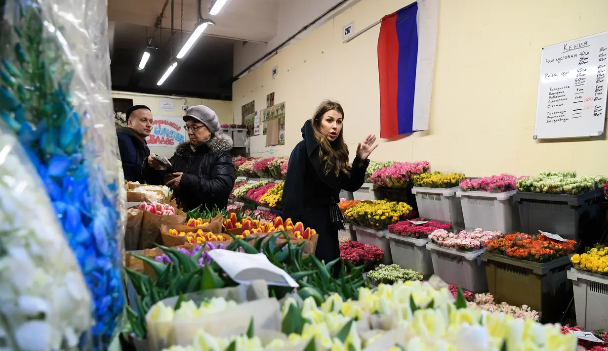 Seorang wanita mencari bunga jelang Hari Perempuan Internasional di pasar bunga di Moskow, Rusia (5/3). Hari Perempuan Internasional jatuh pada tanggal 8 Maret setiap tahunnya. (AFP Photo/Kirill Kudryavtsev)
