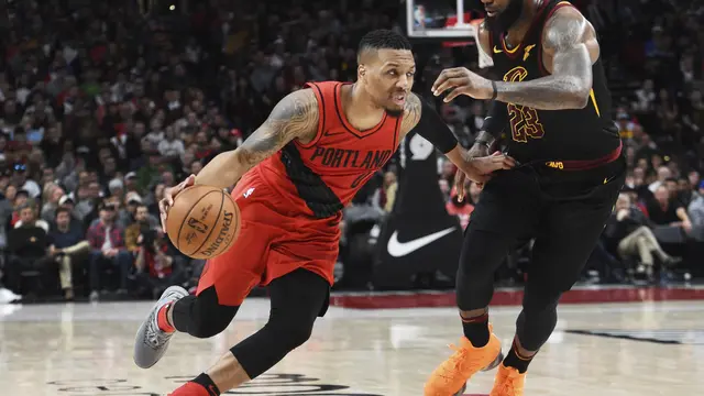 Damian Lillard (merah) berduel dengan LeBron James