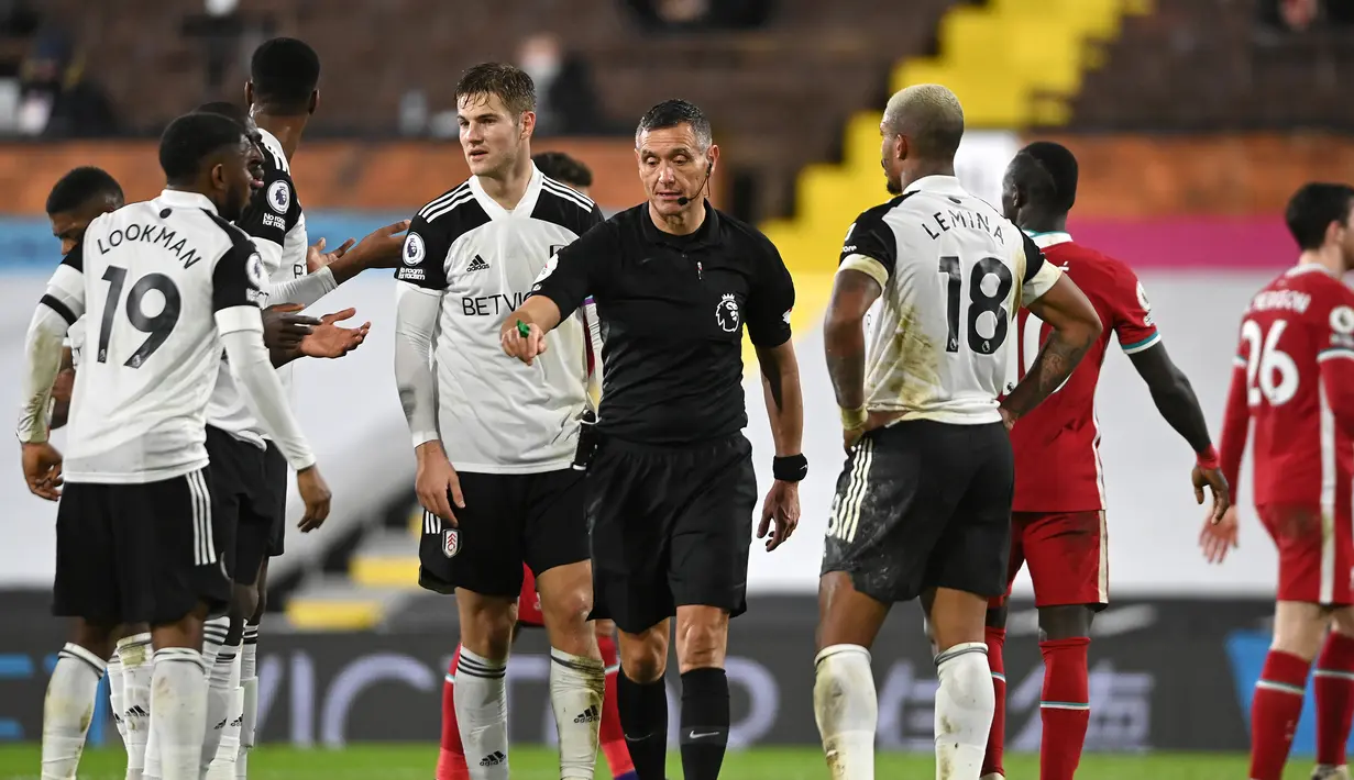 Para pemain Fulham memprotes keputusan wasit Andre Marriner yang memberi tendangan penalti untuk Liverpool dalam laga lanjutan Liga Inggris 2020/21 pekan ke-12 di Craven Cottage, Minggu (13/12/2020). Fulham bermain imbang 1-1 dengan Liverpool. (AFP/Mike Hewitt/Pool)