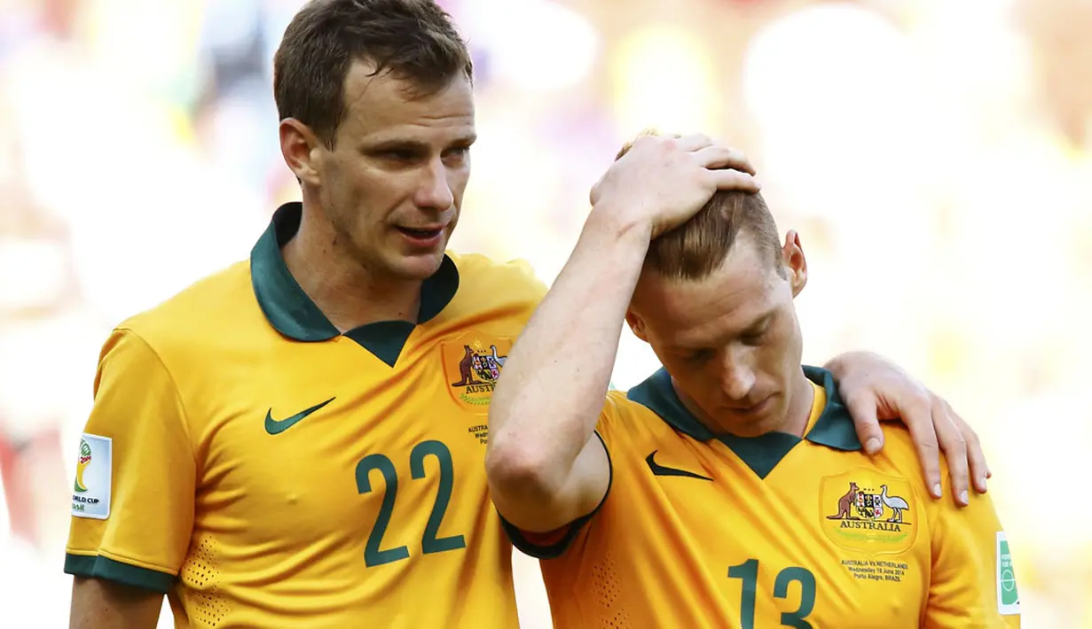Pemain belakang Australia, Alex Wilkinson (kiri) menghibur rekan setimnya, Oliver Bozanic usai dikalahkan Belanda 2-3 di Stadion Beira Rio, Porto Alegre, Brasil, (18/6/2014). (REUTERS/Stefano Rellandini)