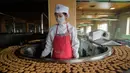 Seorang pekerja berdiri di depan mesin produksi kue merek Taeha di Pabrik Bahan Makanan Unha Taesong, Pyongyang, Korea Utara, 6 April 2021. (KIM Won Jin/AFP)