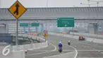 Pekerja melintas di jalan tol akses pelabuhan Tanjung Priok, Jakarta (27/5). Saat ini pekerjaan masih menyisakan pembangunan Seksi E2 dengan rute Cilincing-Jampea sepanjang 2,74 km. (Liputan6.com/Gempur M Surya)