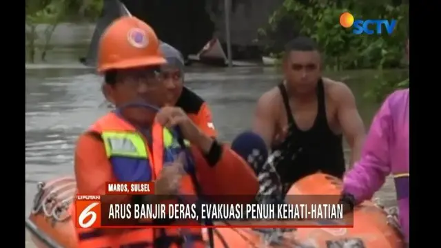 Seorang ibu dan anaknya terkurung banjir setinggi lebih dari satu meter di Moncongloe, Maros, Sulawesi Selatan. Beruntung, petugas berhasil mengevakuasi dengan menyeret melalui perahu karet.