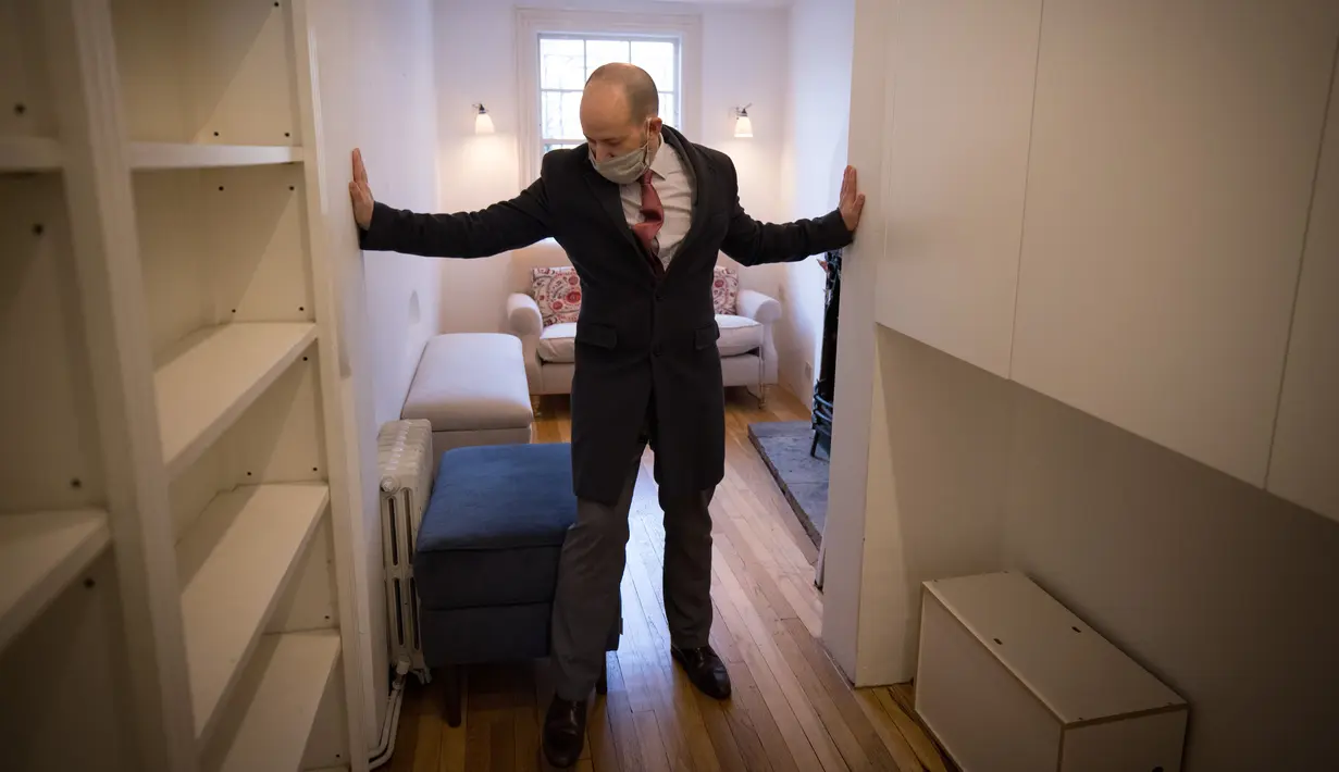 Agen real estate David Myers memimpin tur berkeliling bangunan yang dijuluki "Rumah Tersempit di London" di London barat pada 5 Februari 2021. Rumah unik yang terdiri dari lima tingkat tersebut dibanderol dengan harga mencapai £ 990.000 atau senilai dengan Rp 19,4 miliar. (Tolga Akmen/AFP)