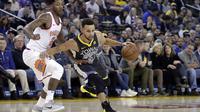 Bintang Golden State Warriors Stephen Curry (kanan) melewati hadangan penggawa Phoenix Suns Elfrid Payton pada laga NBA di Oracle Arena, Senin (12/2/2018) atau Selasa (13/2/2018) WIB. (AP Photo/Marcio Jose Sanchez)