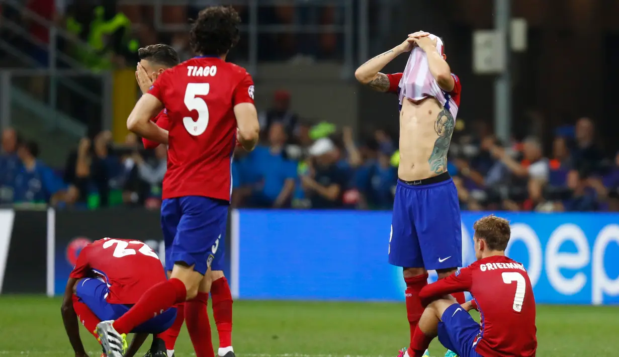 Pemain Atletico Madrid terkulai lemas usai gagal memenangkan Final Liga Champions 2015/2016 di Stadion San Siro, Milan, Minggu (29/5). Atletico harus mengubur mimpi mereka usai kalah 5-3 lewat adu pinalti dengan Real Madrid. (Reuters / Kai Pfaffenbach)