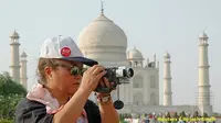 Seorang turis sedang mengambil foto di depan Taj Mahal (Foto: Reuters via Boom Live)