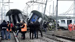 Tim penyelamat mengevakuasi korban keluar dari sebuah kereta di Stasiun Pioltello Limito, Milan, Italia, Kamis (25/1). Carabinieri mengatakan kereta komuter yang membawa ratusan penumpang tergelincir. (Flavio Loscalzo/ANSA via AP)